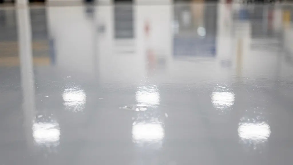 Gros plan sur la surface brillante d'un plancher époxy commercial montrant les reflets lumineux